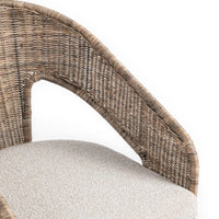 Close-up of a woven wicker chair back and light beige upholstered seat cushion on a white background.
