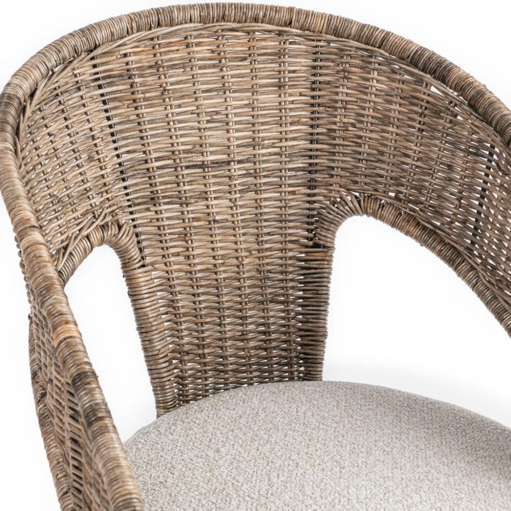 Close-up of a woven wicker chair back and armrest with a light beige textured seat cushion on a white background.