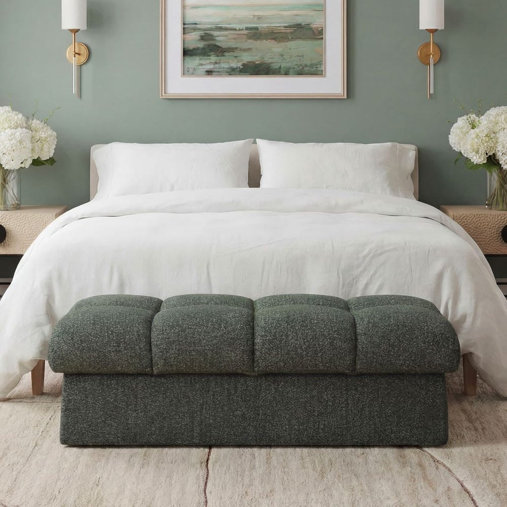 Moss green and blue ottoman in front of a bed with white bedding and a green wall.