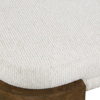 Close-up of a textured white cushion on a wooden bench leg.