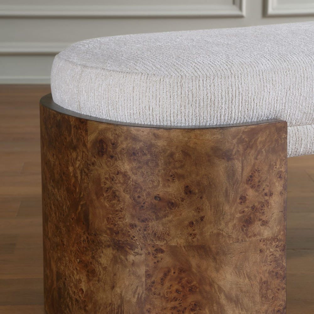 Stool with textured brown base and light gray cushioned top on a wooden floor.