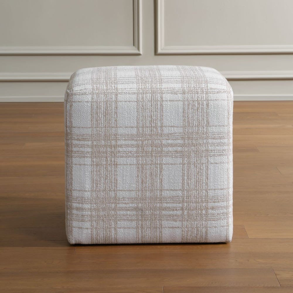 Textured ottoman on a wooden floor with neutral wall background