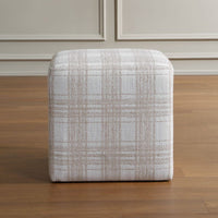Textured ottoman on a wooden floor with neutral wall background