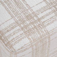 Close-up of a textured fabric with a beige and off-white plaid pattern.
