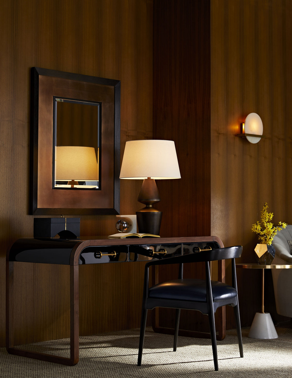 Victoria Black Lacquer Desk by Arteriors, paired with a lamp, chair, mirror, and decor in a wood-paneled room.