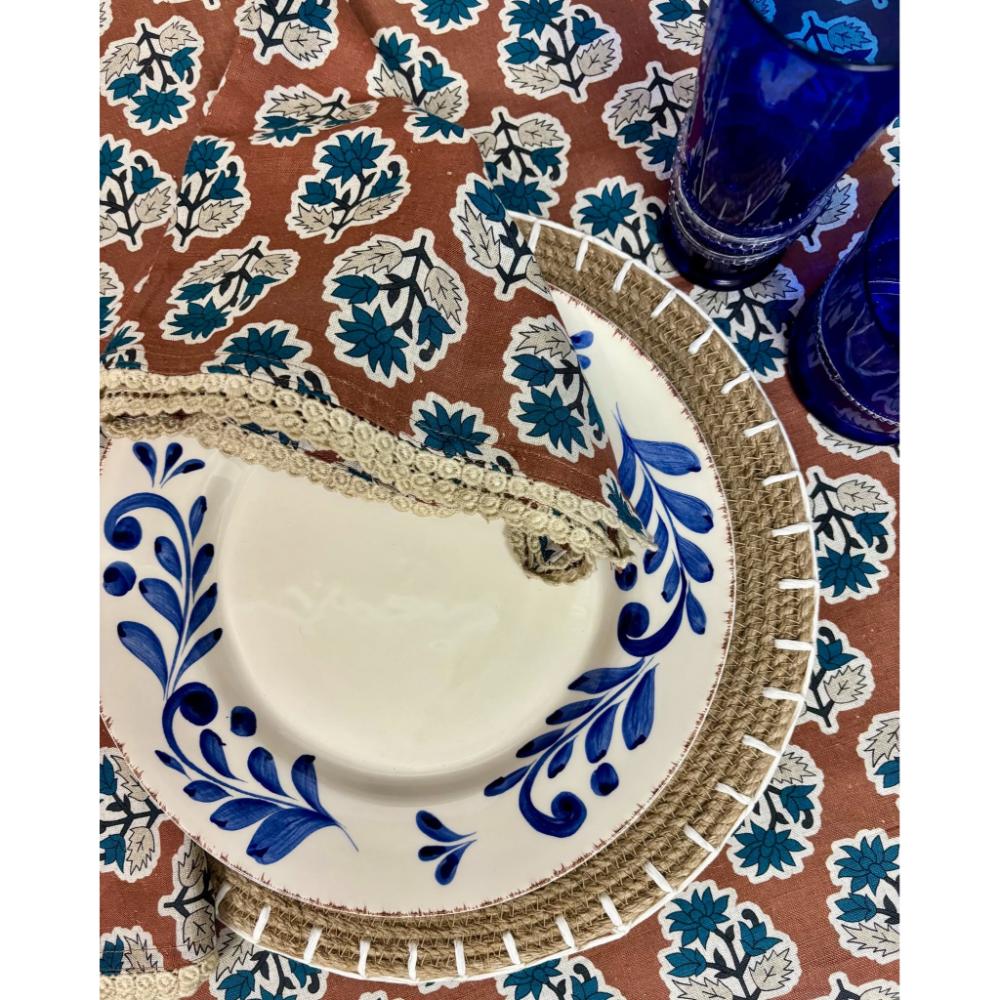 Abigails Cinnamon + Blue Floral Lace Trim Napkins add Cotswolds flair to any table with blue plates and glasses.