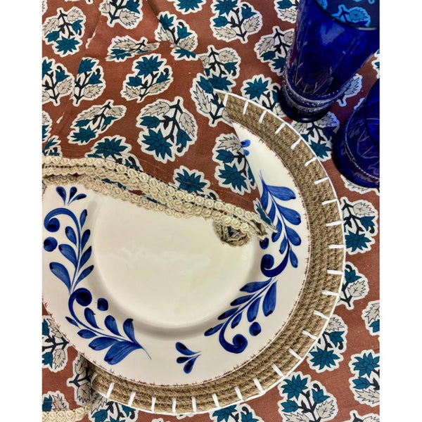 Abigails Cinnamon + Blue Floral Lace Trim Napkins add Cotswolds flair to any table with blue plates and glasses.