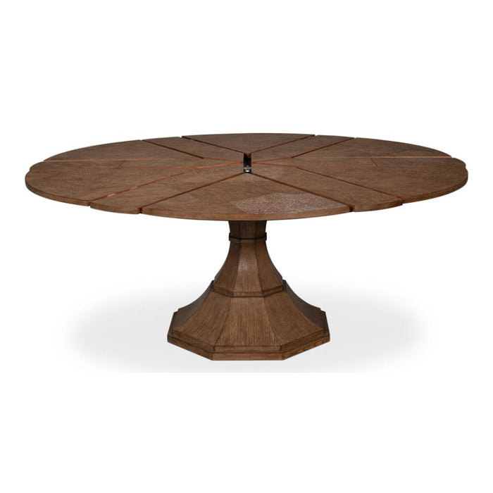 A round wooden dining table with a segmented top and a fluted pedestal base, shown on a plain white background.