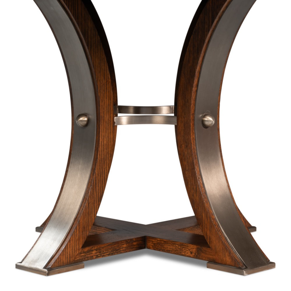 The Sarreid, Ltd. Tower Palladio Finish Medium Jupe Dining Table features curved legs and a cross-shaped oak base.