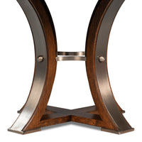 The Sarreid, Ltd. Tower Palladio Finish Medium Jupe Dining Table features curved legs and a cross-shaped oak base.