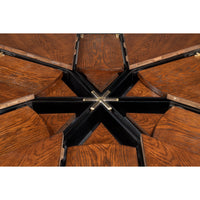 Close-up of a Sarreid, Ltd. Tower Palladio Finish Medium Jupe Dining Table with opened black and brass compartments.