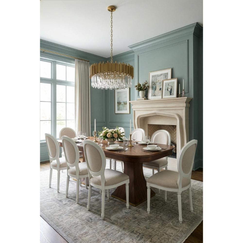 Elegant dining with Sarreid Gramercy Park Walnut Jupe Table, 8 chairs, chandelier, fireplace, and large window.