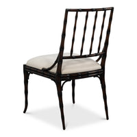 A dark brown bamboo-style dining chair with a light beige upholstered seat cushion, shown from a three-quarter angle on a white background.