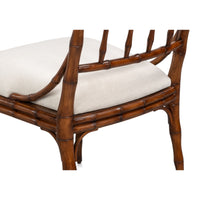 A close-up of a dining chair with a brown bamboo-look frame and a light beige upholstered seat cushion, shown against a plain white background.