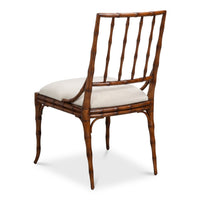 A side dining chair with a brown bamboo-look frame and a light beige upholstered seat cushion, shown from a three-quarter angle on a white background.