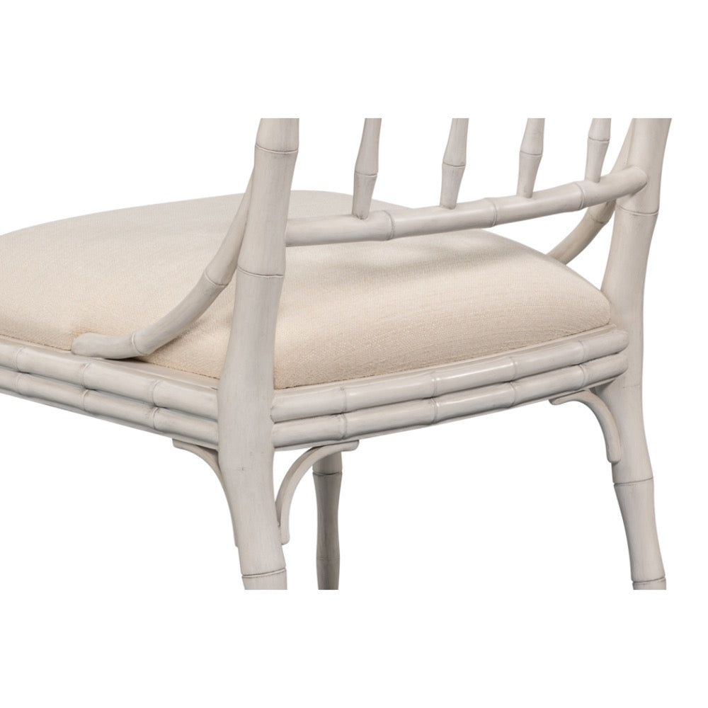 White rattan chair with beige cushion on a white background
