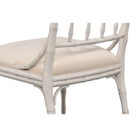 White rattan chair with beige cushion on a white background