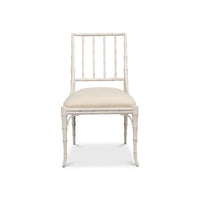 A single dining chair with a white faux-bamboo frame and a cream upholstered seat cushion, shown against a plain white background.
