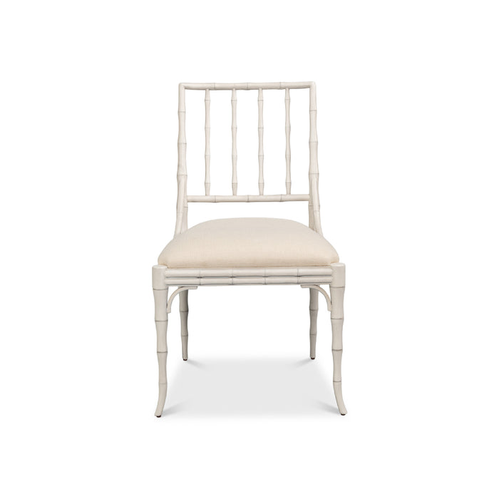 A single dining chair with a white faux-bamboo frame and a cream upholstered seat cushion, shown against a plain white background.