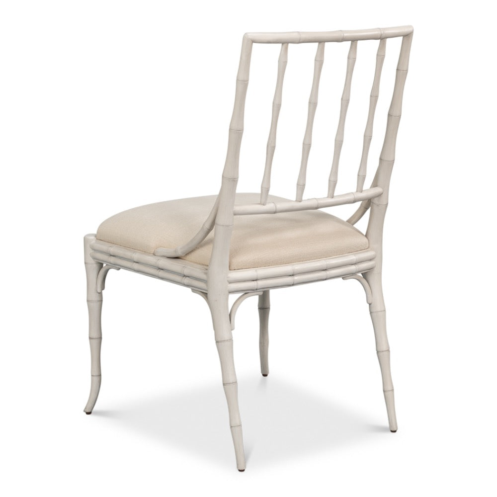 White rattan chair with beige cushion on a white background