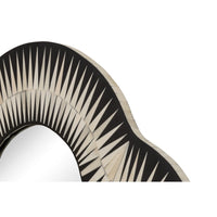 A close-up of a decorative arch-shaped mirror frame with alternating black and cream radial spokes, showing a reflective curved opening against a white background.
