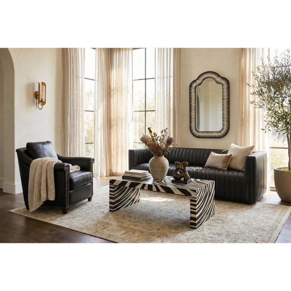 Modern living room with black sofa, armchair, zebra table, and Sarreid's Meridian Bone Inlay Mirror by the windows.