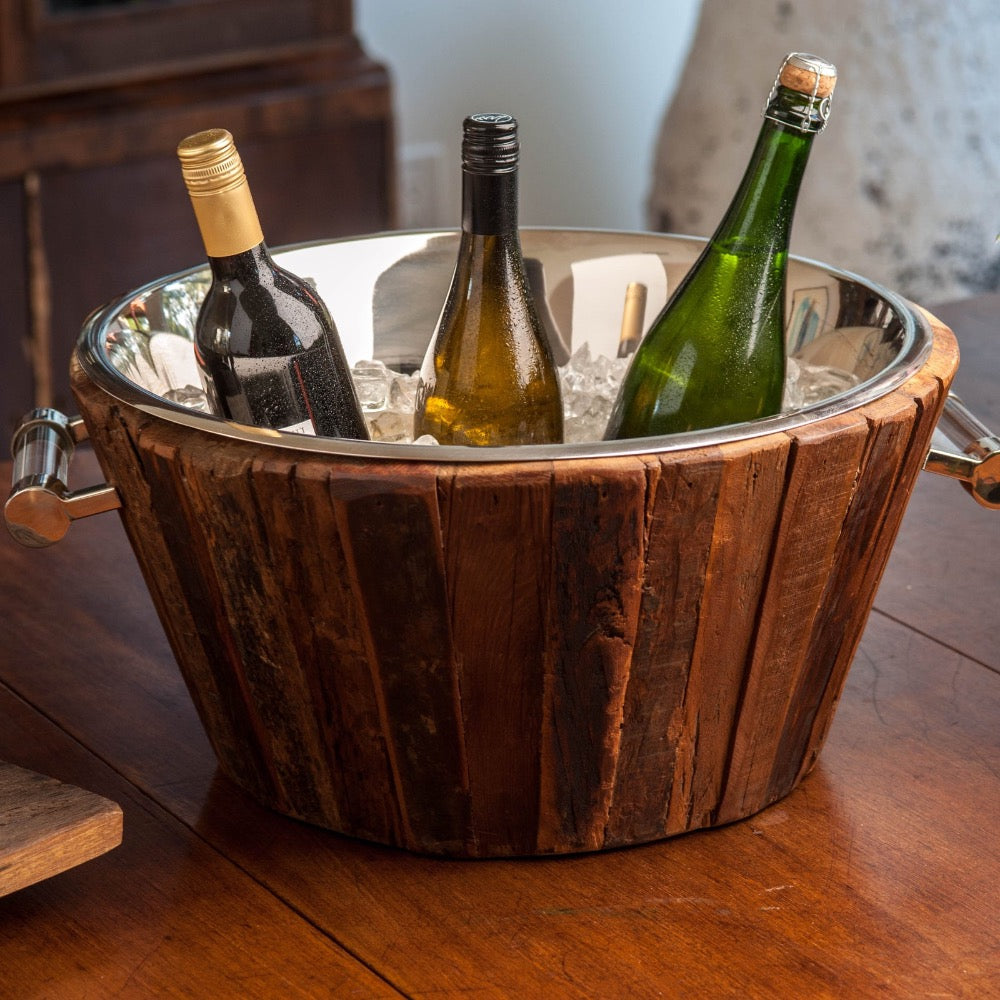Wooden ice bucket with wine bottles on a wooden surface