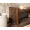 A Classic Home Reclaimed Wood Bench sits by a concrete planter, with books and a basket on a wooden floor.