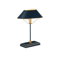 A modern table lamp with a dark navy blue shade and base accented by gold metal details, set against a plain white background.