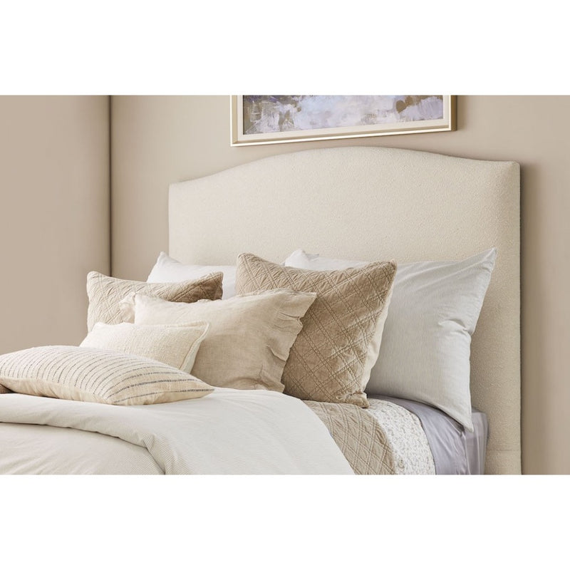 cream upholstered head board pillows on bed