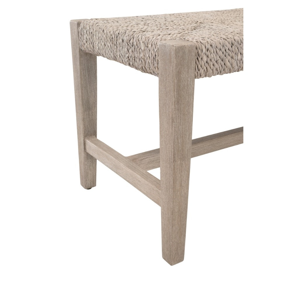 Close-up of a wooden bench or stool leg with a woven natural-fiber seat on a white background.