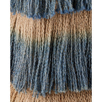 Close up of corner view of jute and blue fringe ottoman