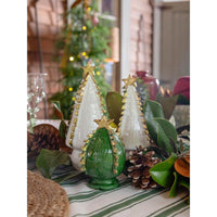 Two Ceramic White Christmas Tree with Gold Accents Medium and one green handcrafted tree with gold stars on a table.