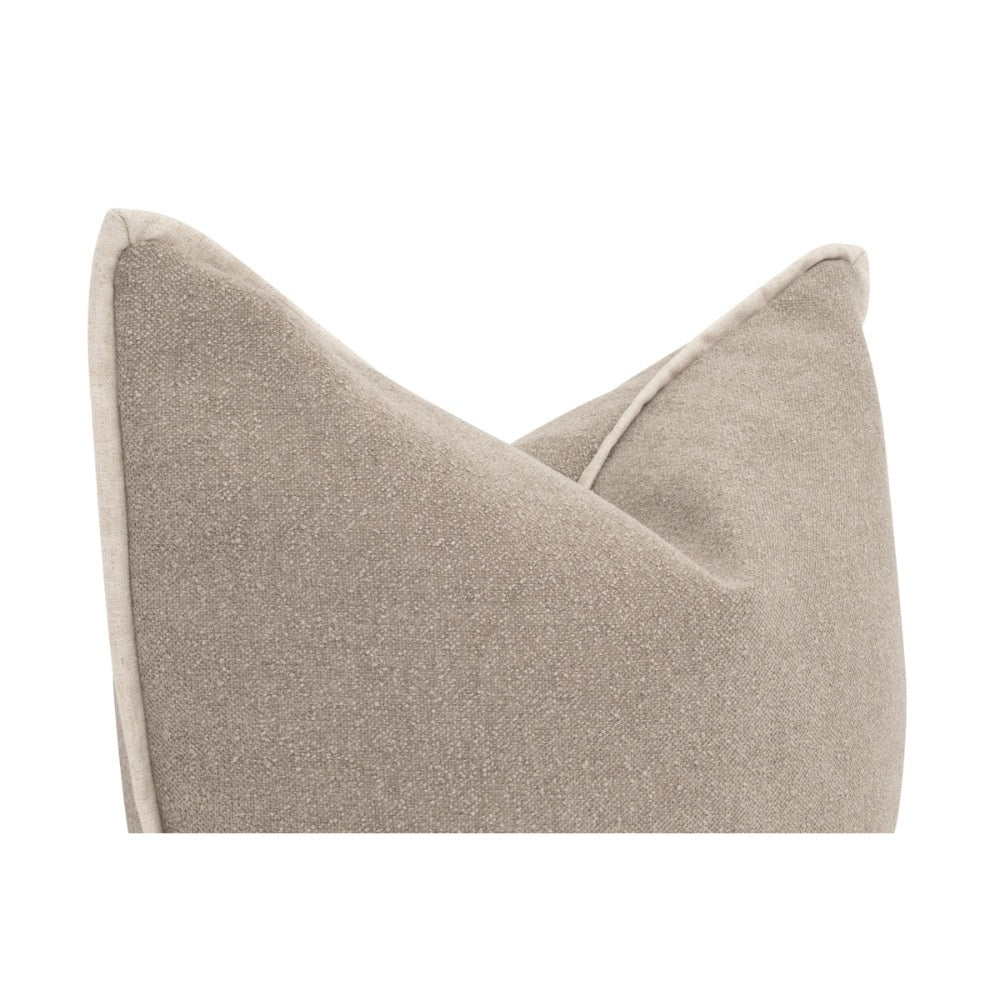 A close-up of a textured throw pillow in a warm taupe-beige color, showing the fabric weave and a subtle light-colored piping detail along the edge, set against a solid white background.