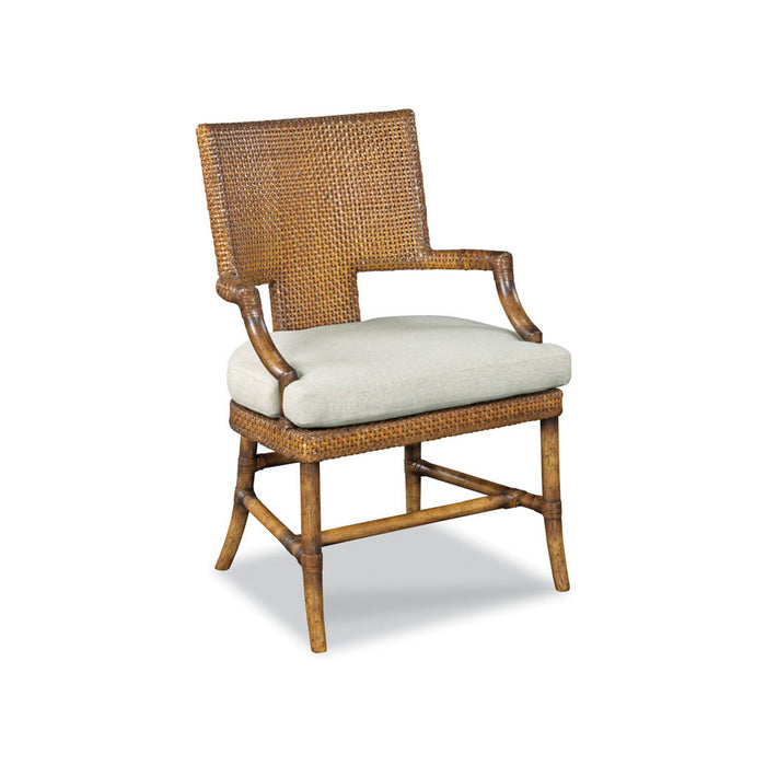 A wicker dining chair with a woven brown backrest and frame, curved armrests, and a light beige upholstered seat cushion, shown on a white background.
