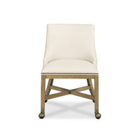 An upholstered accent chair with a cream fabric seat and backrest, a natural wood frame, and brass nailhead trim on the front apron, shown against a plain white background.