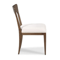 A mid-century modern dining chair with a dark brown wood frame and a textured off-white upholstered seat, shown from a three-quarter angle on a white background.