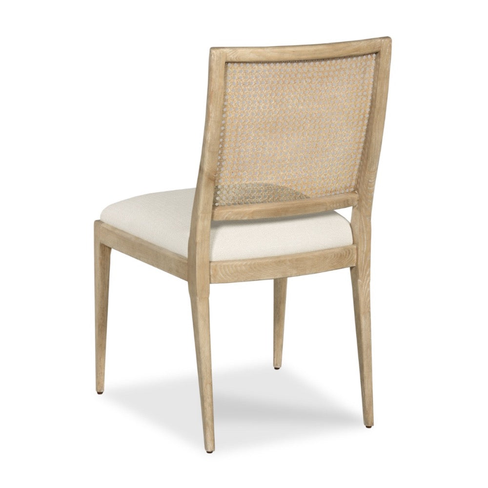 A light natural wood dining chair with a woven cane backrest and a cream upholstered seat, shown from a three-quarter angle on a white background.
