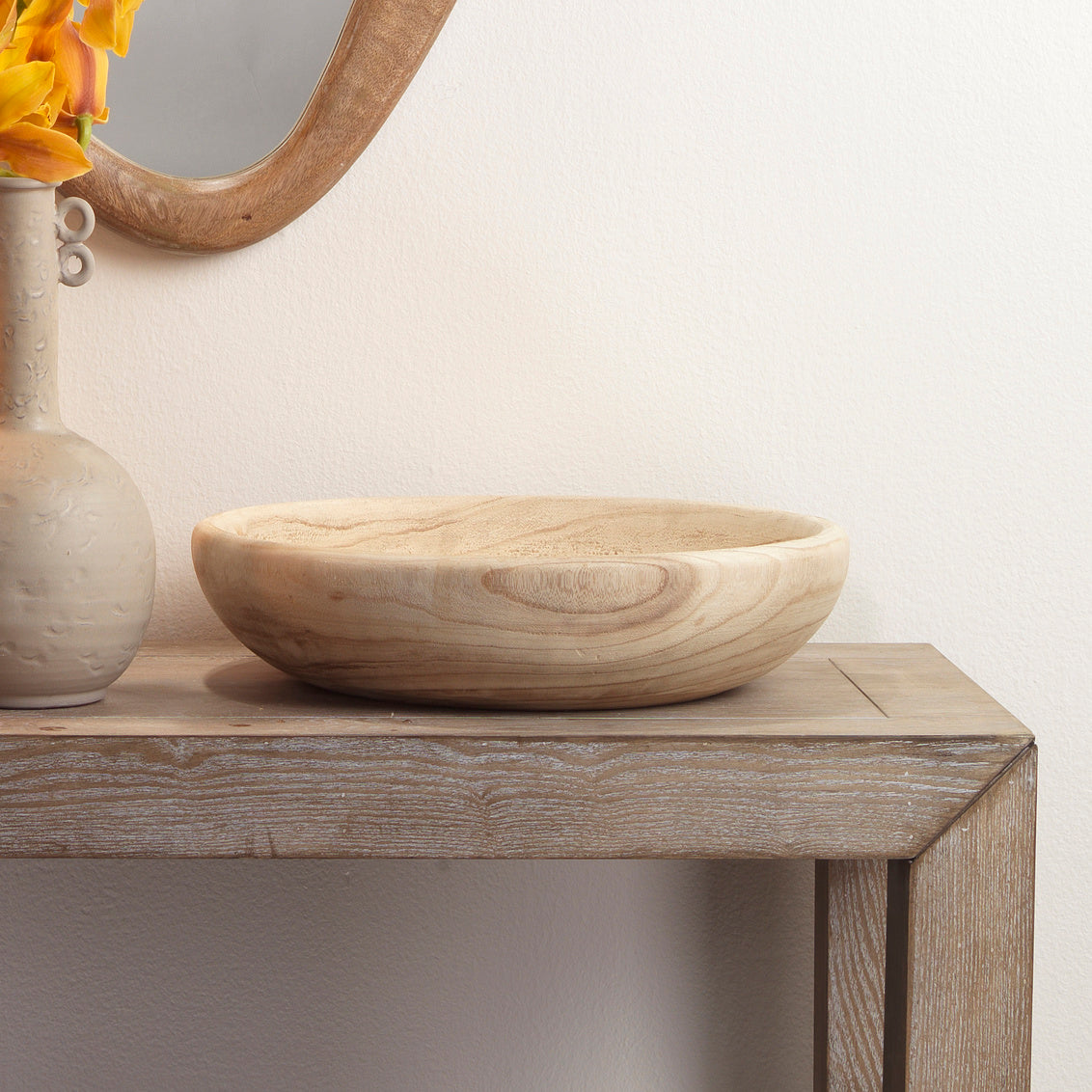 Jamie Young Laurel Small Paulownia Wood Bowl on rustic table with carved vase and mirror, showcasing organic beauty.