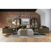 Modern living room with green sofas, a coffee table, and decorative elements against a brick wall.