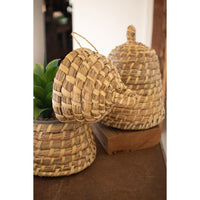 Woven baskets on a wooden surface with a plant in the background