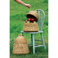 Woven baskets with fruits on a green chair against a grassy background