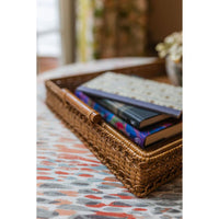 Rattan tray with books on a patterned surface