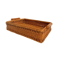Woven brown wicker basket with handles on a white background