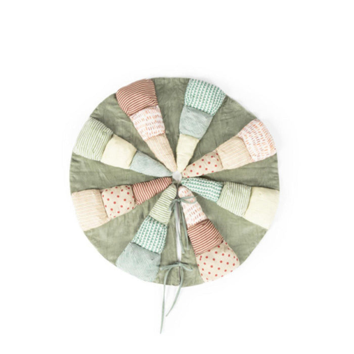 A round patchwork christmas tree skirt with a sage green base and multiple stitched fabric segments in pastel pink, beige, mint green, and light blue, finished with a drawstring closure, shown on a plain white background.