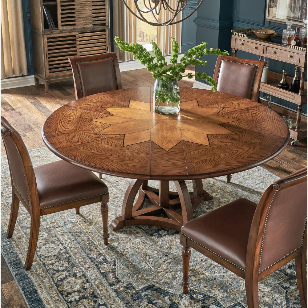 Round wooden dining table with four chairs in a room with decorative elements.