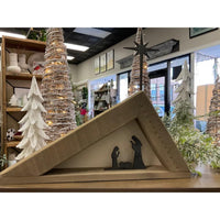 Brayden & Brooks' Reclaimed Wood + Canvas Nativity Scene framed in a triangle with trees and holiday decor in the background.