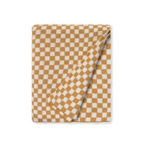 A folded checkered blanket or throw in a warm mustard yellow and cream gingham pattern, shown on a clean white background.