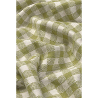 A close-up of a woven fabric with a green and off-white gingham check pattern, shown with soft folds and texture.