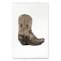 Art print featuring a sepia-toned photograph of a distressed western cowboy boot, displayed on a white sheet of paper with torn edges against a white background.